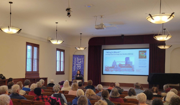 Jessica Chen speaking to a full room about Wing's Block's heritage designation