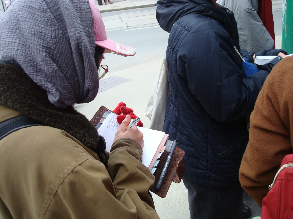 JIA team member jotting down notes in their pocket notebook.